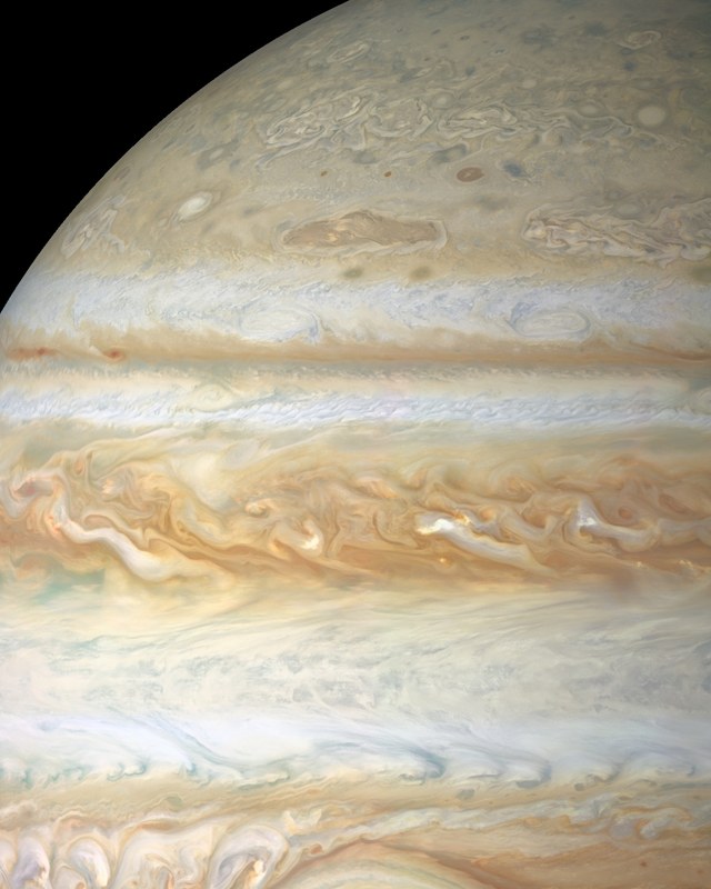 茶色の北赤道ベルトに白い雲が渦巻き、その上に北半球の縞模様と惑星の縁が続く / The brown North Equatorial Belt with swirling white clouds, and above it the northern belts and zones up to the limb